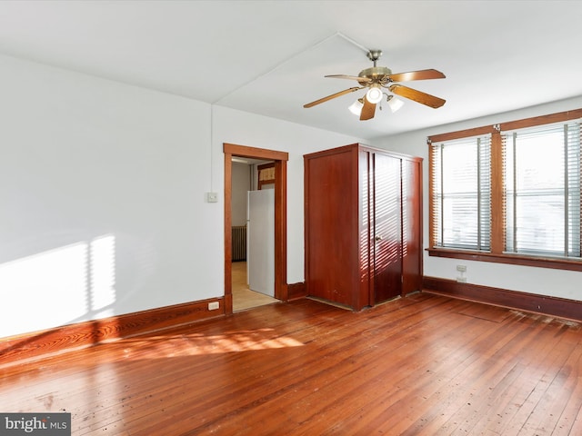 unfurnished room with radiator, hardwood / wood-style flooring, and ceiling fan