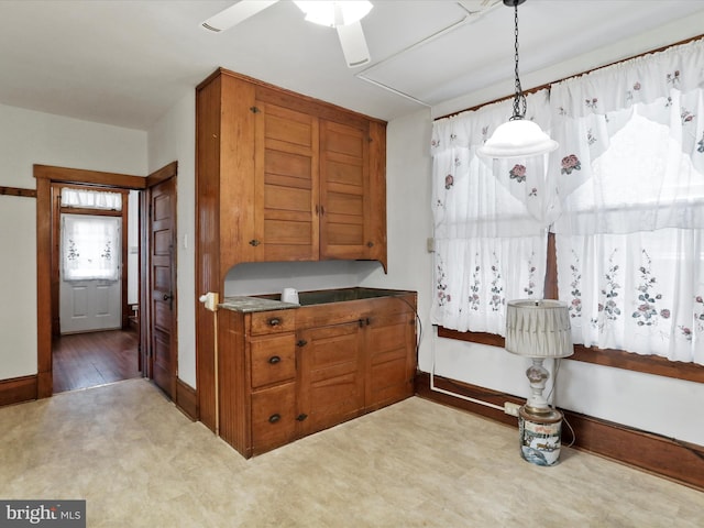 kitchen with ceiling fan, hanging light fixtures, and light carpet