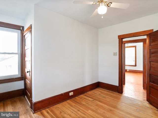 empty room with ceiling fan and light hardwood / wood-style flooring