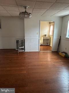 empty room with hardwood / wood-style flooring and a paneled ceiling