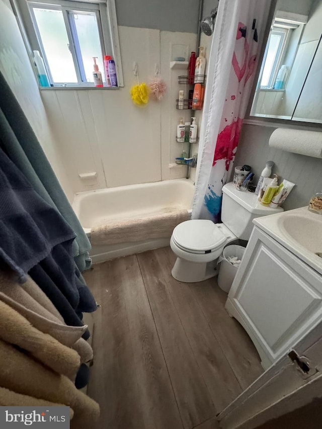 full bathroom with vanity, hardwood / wood-style floors, shower / bath combo with shower curtain, and toilet