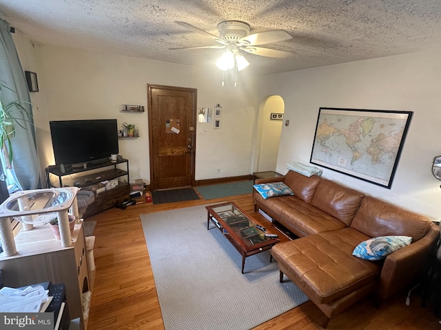 living room featuring a textured ceiling, hardwood / wood-style flooring, and ceiling fan