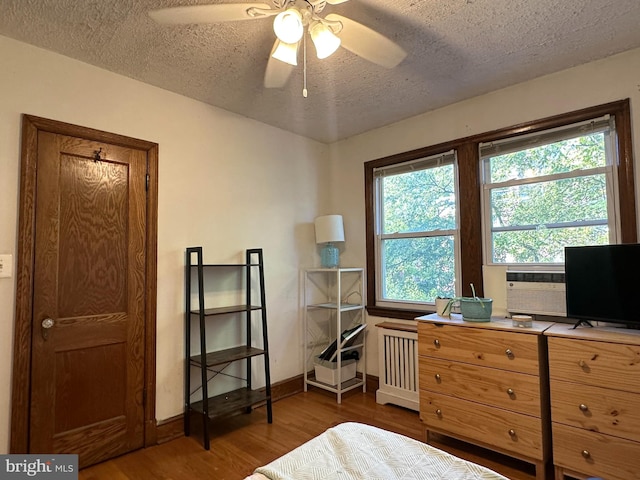 bedroom with radiator, ceiling fan, a textured ceiling, and dark hardwood / wood-style flooring