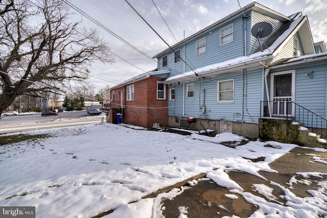 view of snow covered rear of property