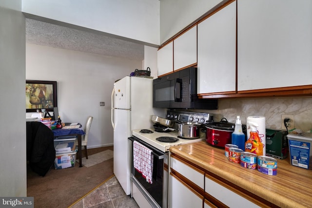 kitchen featuring decorative backsplash, white cabinetry, and white appliances