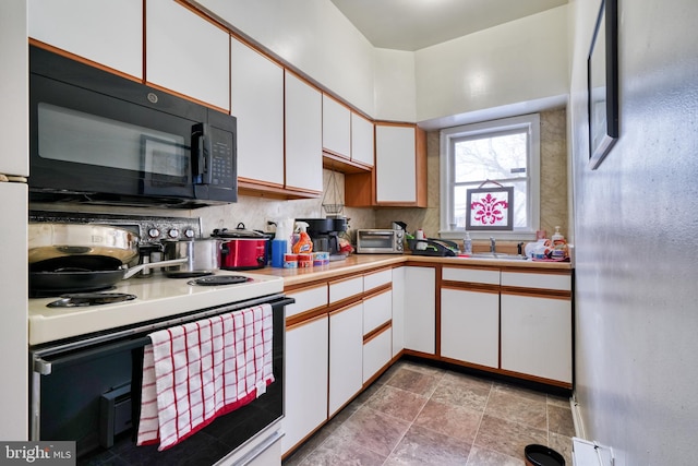 kitchen featuring white range with electric stovetop, white cabinets, and backsplash