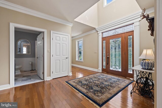 foyer entrance with hardwood / wood-style flooring and ornamental molding