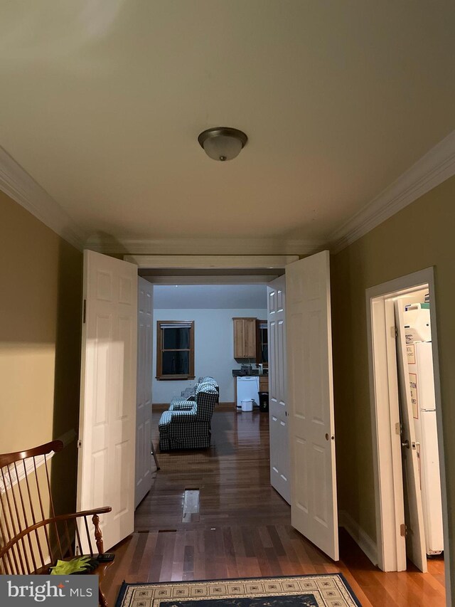 hallway with ornamental molding and dark hardwood / wood-style flooring