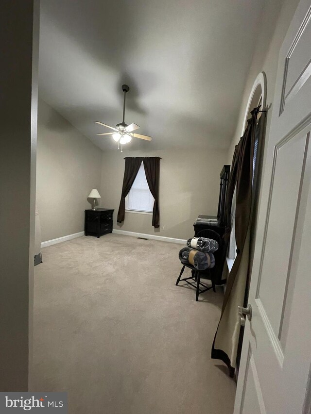 living area featuring light colored carpet and ceiling fan