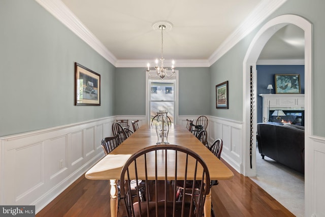 dining area featuring crown molding, an inviting chandelier, and dark hardwood / wood-style floors