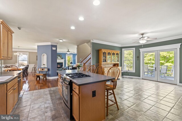 kitchen featuring a kitchen island, crown molding, stainless steel appliances, and a breakfast bar