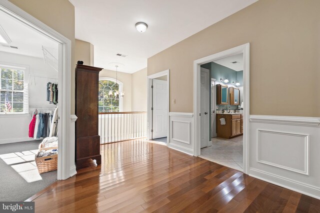 interior space featuring a chandelier, wood-type flooring, and a healthy amount of sunlight