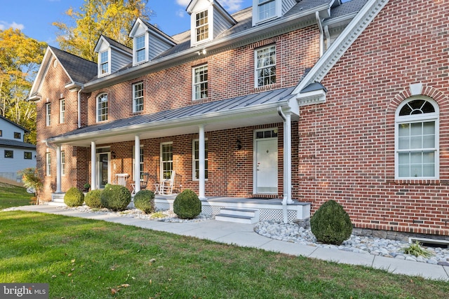 view of front of home with a front yard and a porch