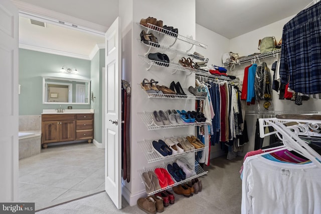 spacious closet featuring sink and light tile patterned floors