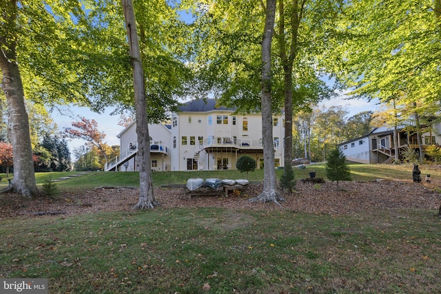 rear view of house featuring a yard and a deck