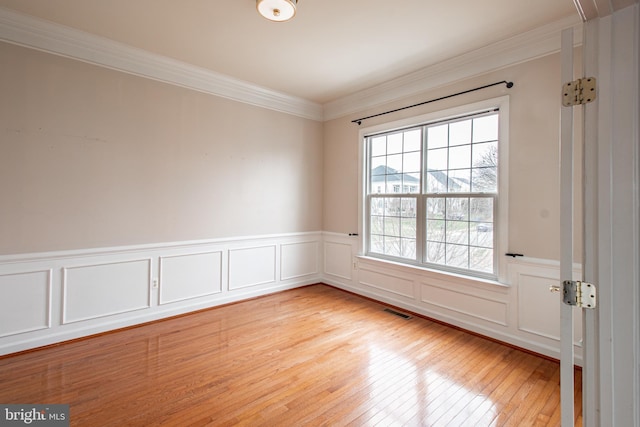 unfurnished room with crown molding and light wood-type flooring