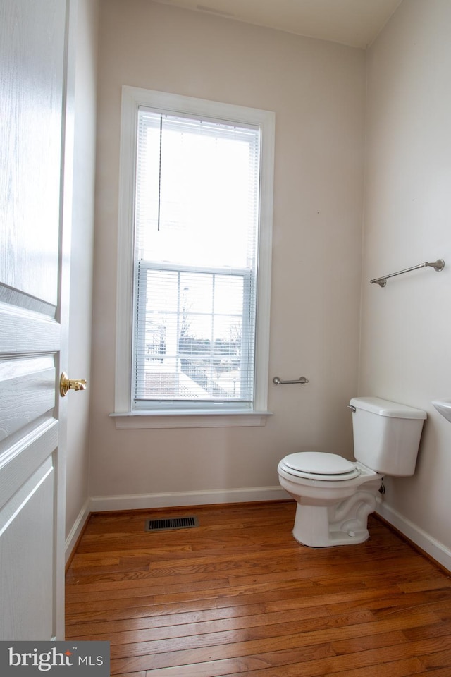 bathroom with toilet and hardwood / wood-style flooring