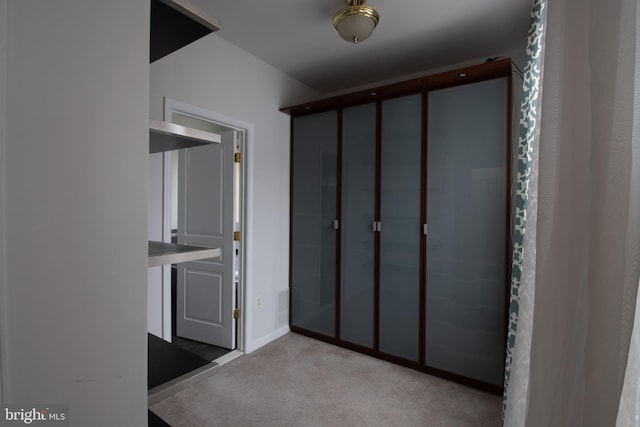 hallway featuring light colored carpet