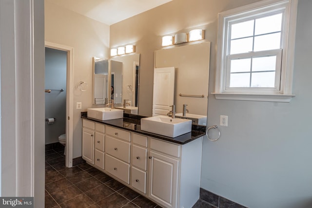 bathroom featuring tile patterned floors, vanity, and toilet