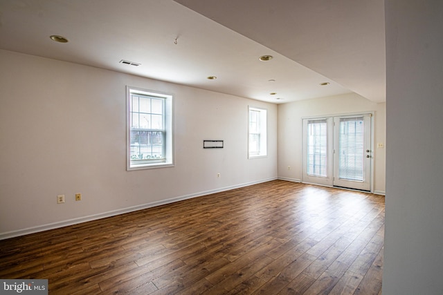 unfurnished room with dark hardwood / wood-style flooring and plenty of natural light