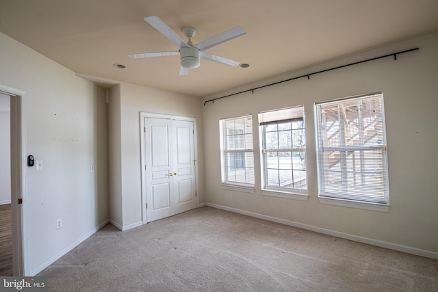 unfurnished bedroom featuring light carpet, a closet, and ceiling fan