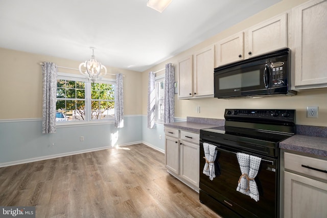 kitchen featuring an inviting chandelier, white cabinetry, black appliances, and light wood-type flooring