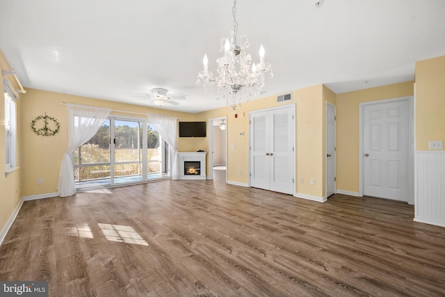 unfurnished living room with hardwood / wood-style floors and ceiling fan with notable chandelier