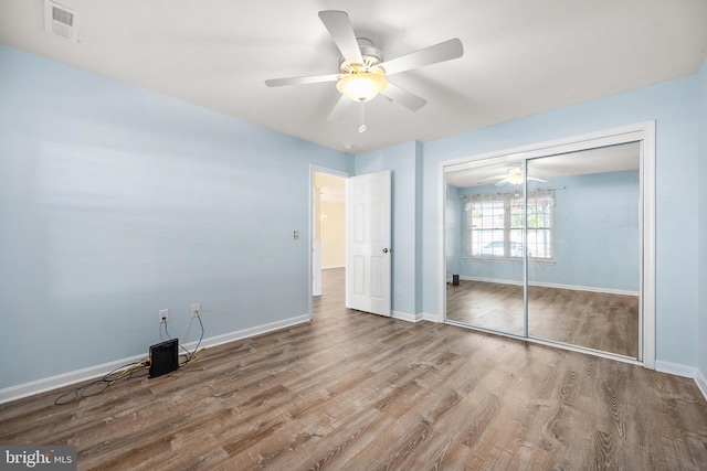 unfurnished bedroom featuring a closet, light wood-type flooring, and ceiling fan