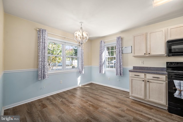 kitchen featuring a chandelier, black appliances, dark wood-type flooring, and pendant lighting