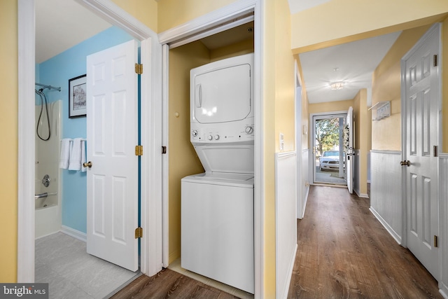 laundry area featuring wood-type flooring and stacked washer and dryer