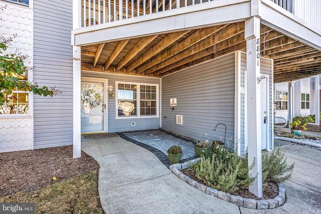 view of exterior entry with a patio and a balcony