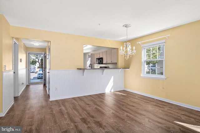 kitchen with a kitchen breakfast bar, kitchen peninsula, dark hardwood / wood-style floors, and a healthy amount of sunlight