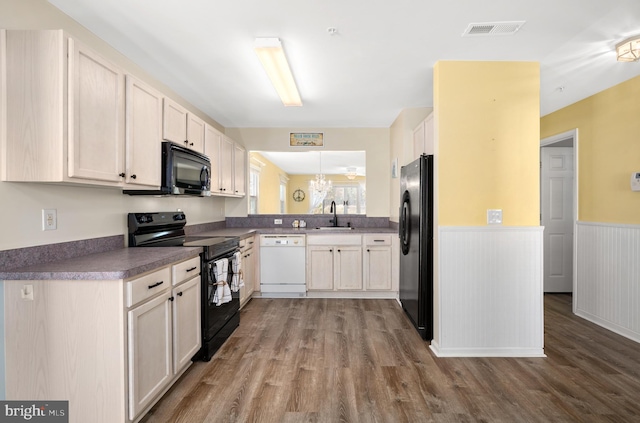 kitchen featuring kitchen peninsula, hardwood / wood-style floors, black appliances, and sink