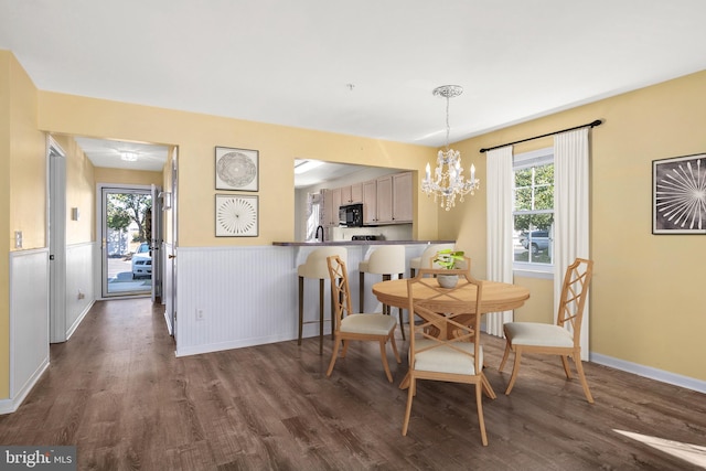 dining space with dark wood-type flooring and a chandelier