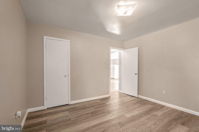 unfurnished room with hardwood / wood-style flooring