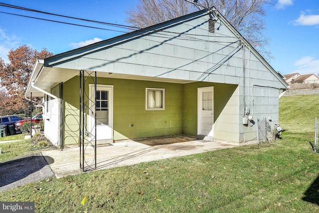 rear view of property featuring a patio area and a yard