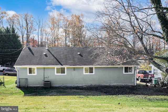 rear view of house featuring a lawn and central air condition unit