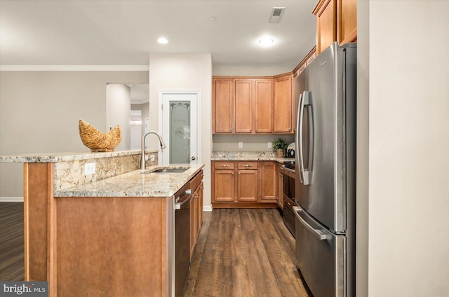 kitchen featuring sink, stainless steel appliances, dark wood-type flooring, ornamental molding, and a kitchen island with sink