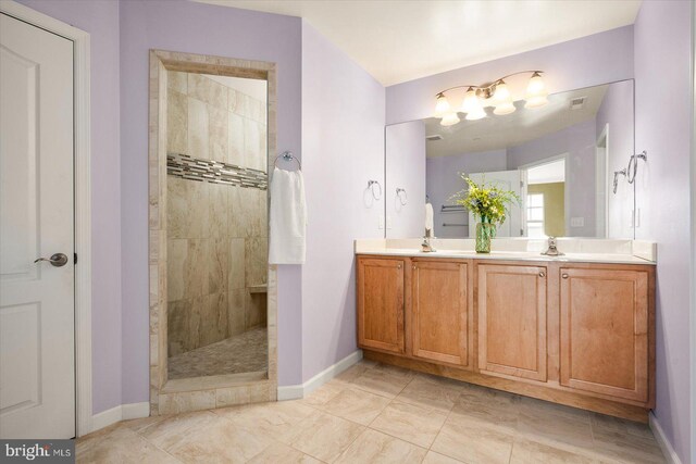 bathroom with vanity and a tile shower