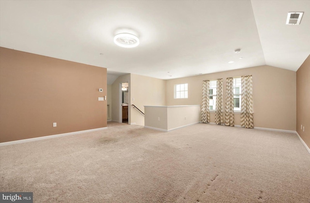 unfurnished room with lofted ceiling and light colored carpet