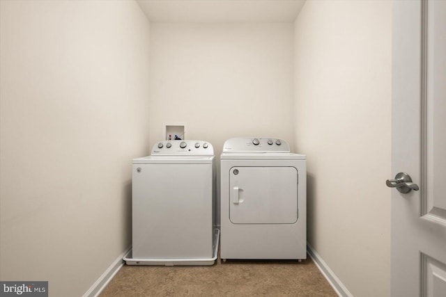 laundry room featuring light colored carpet and separate washer and dryer