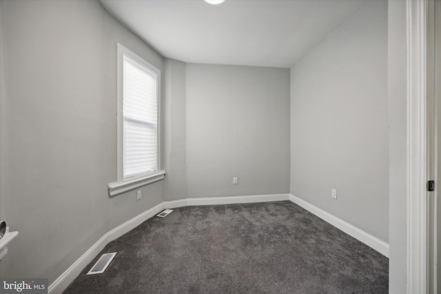 unfurnished room with dark colored carpet