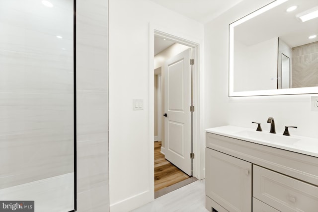 bathroom featuring vanity, hardwood / wood-style flooring, and a tile shower