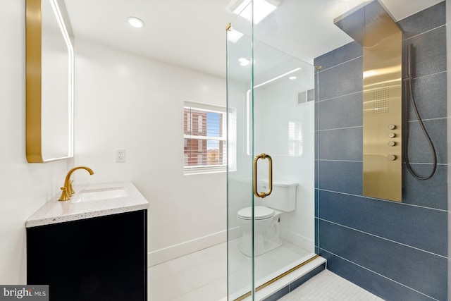 bathroom with vanity, toilet, a shower with shower door, and tile patterned flooring