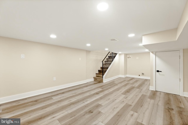 basement with light hardwood / wood-style flooring