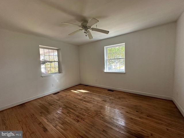 spare room with dark hardwood / wood-style floors and ceiling fan