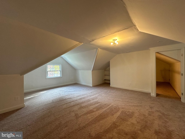 bonus room with carpet floors and vaulted ceiling