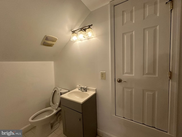 bathroom featuring vanity, toilet, lofted ceiling, and tile patterned flooring