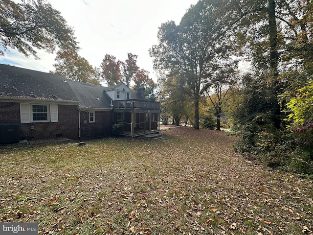 view of yard with central AC unit and a sunroom