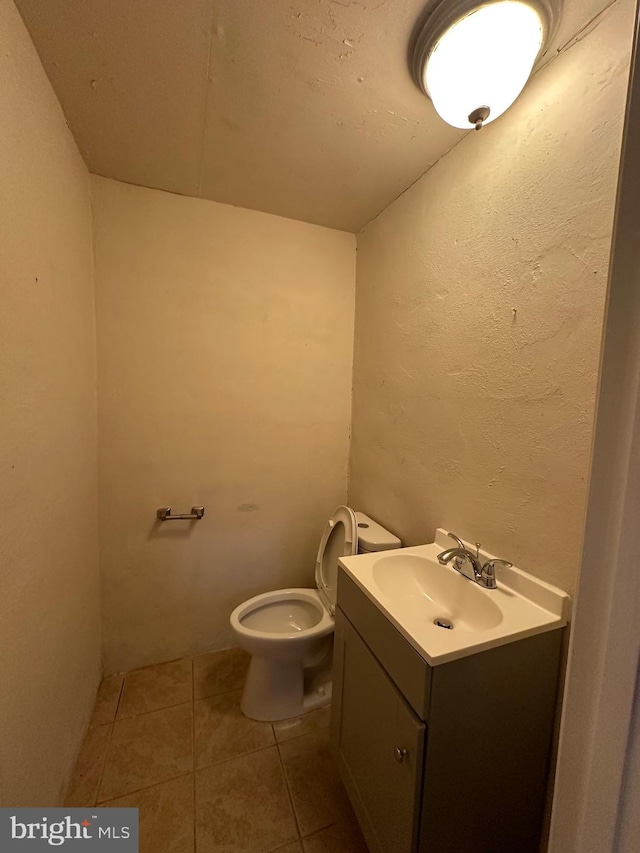 bathroom featuring toilet, vanity, and tile patterned flooring